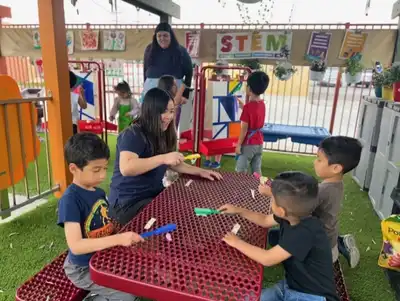 Young children learning social skills, sharing, manners, and independence through classroom community activities at Kids Adventure Learning Center