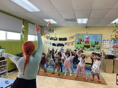 Young students practicing mindful yoga poses and breathing exercises during a calming yoga enrichment session at Kids Adventure Learning Center