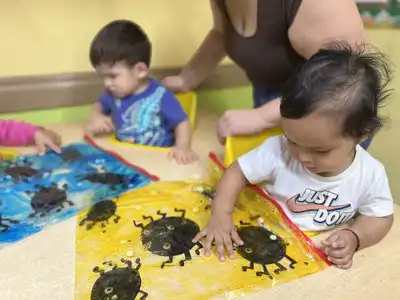 Infants exploring a sensory activity that supports early motor and cognitive development at Kids Adventure Learning Center