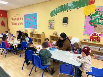 Teacher conducting individualized assessment and observation to create customized lesson plans for Pre-K child development at Kids Adventure Learning Center