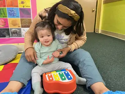 Child learning to play instruments in Kids Adventure Learning Center's music enrichment program developing rhythm, melody, and musical expression